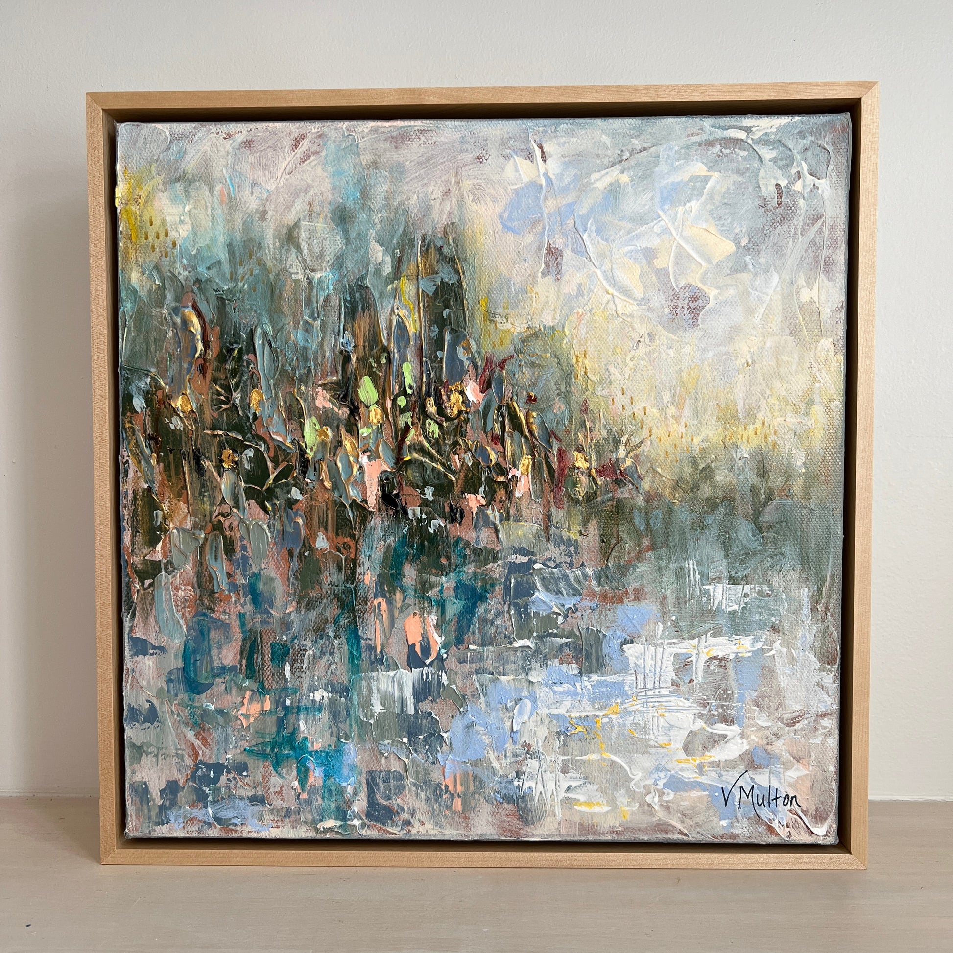 Abstract painting in a wooden frame on a white wall